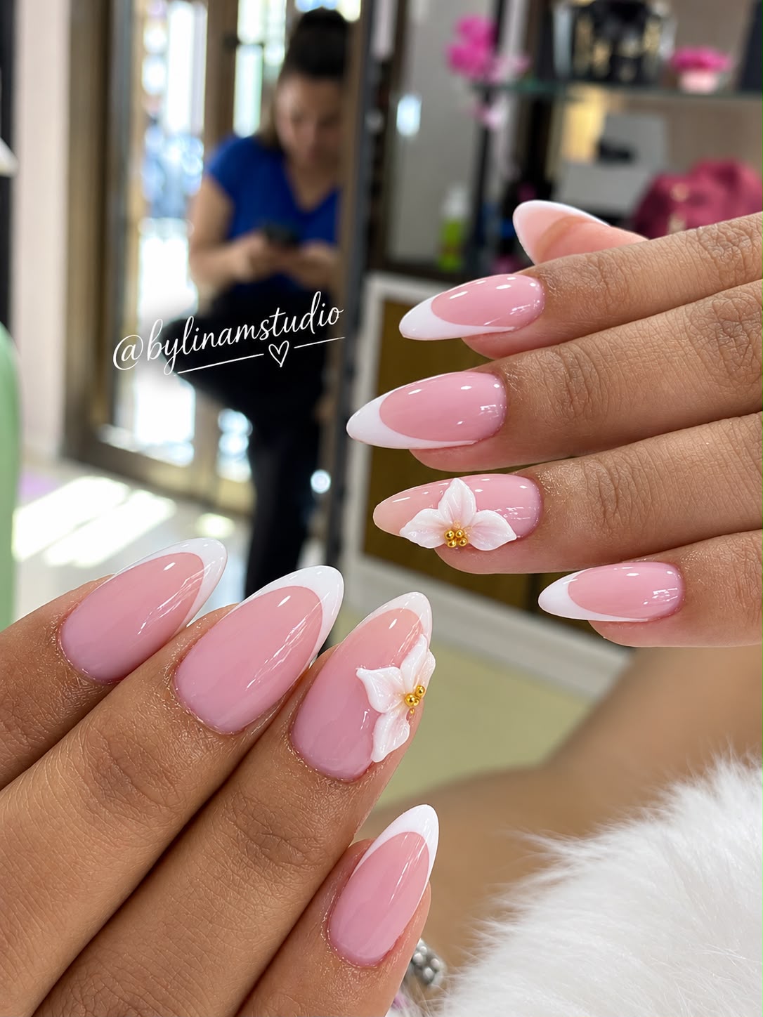 Manicura almendrada rosa con francesa blanca y flor en relieve dorado
