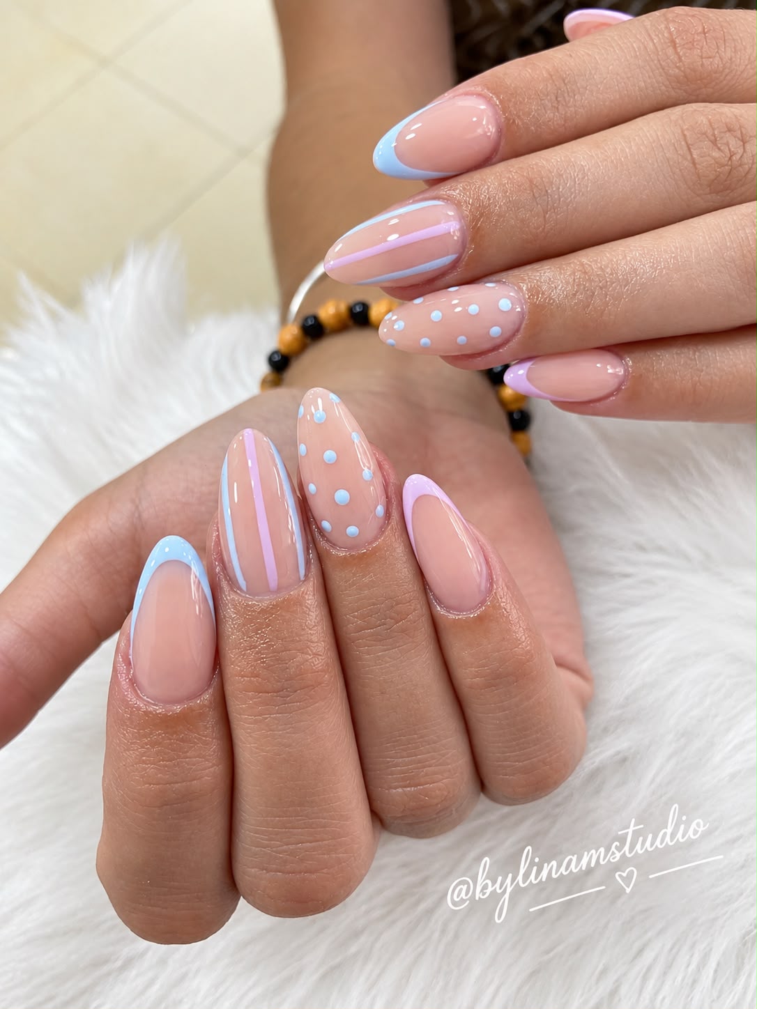 Manicura con líneas y lunares en azul y rosa