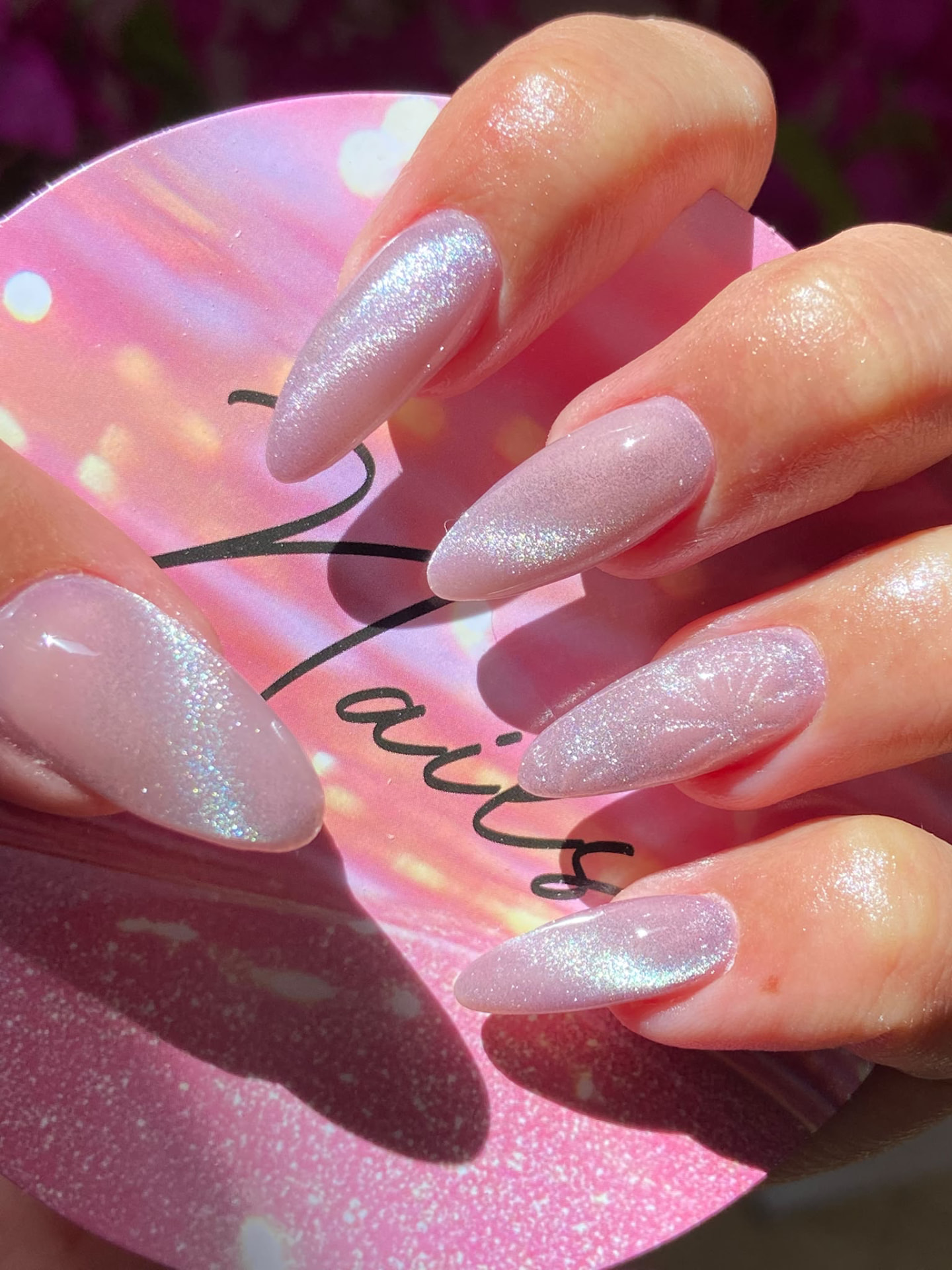Manicura almendrada rosa con efecto ojo de gato y patrón floral
