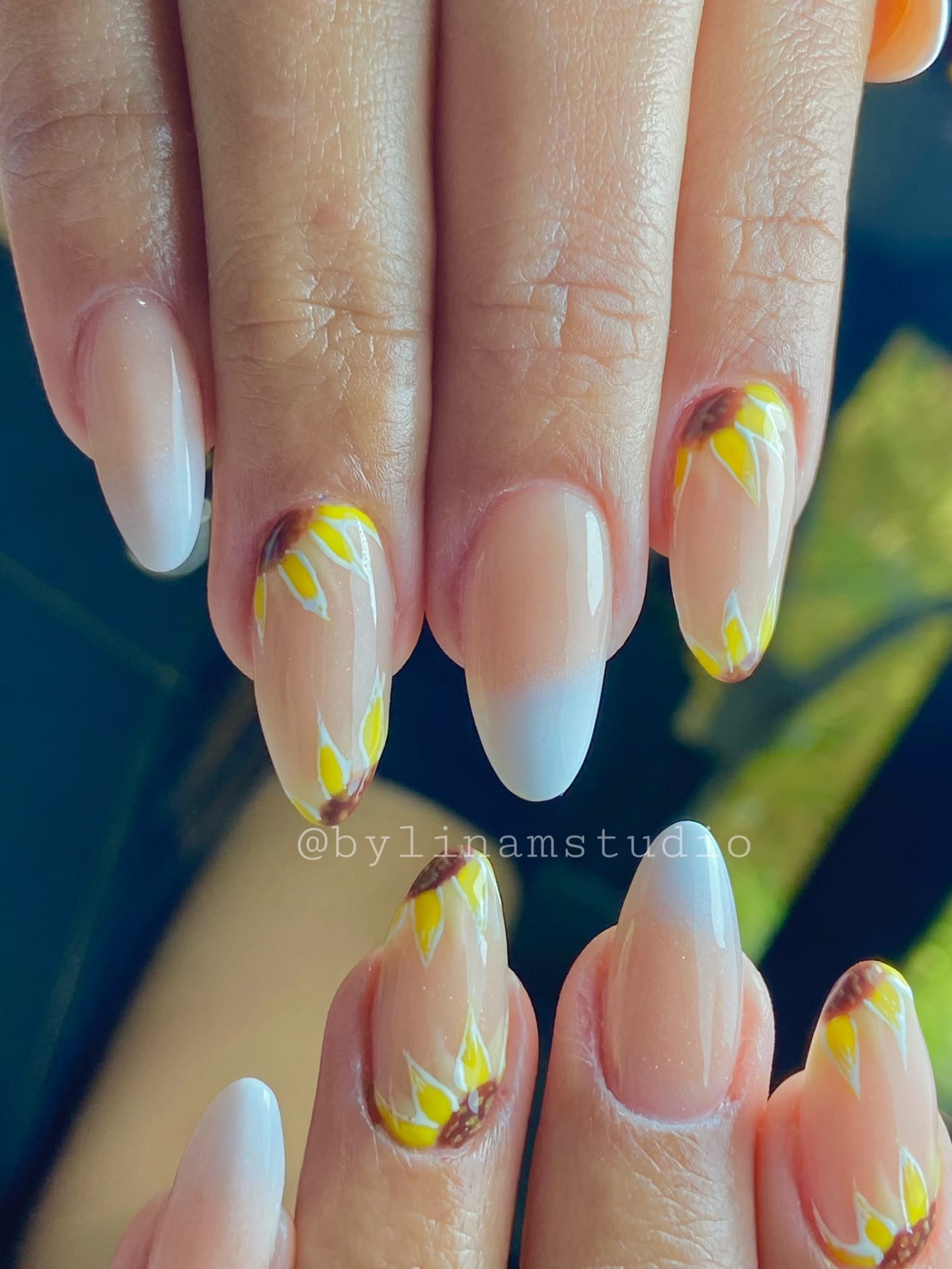 Manicura almendrada nude con francesa degradada blanca y girasoles pintados a mano