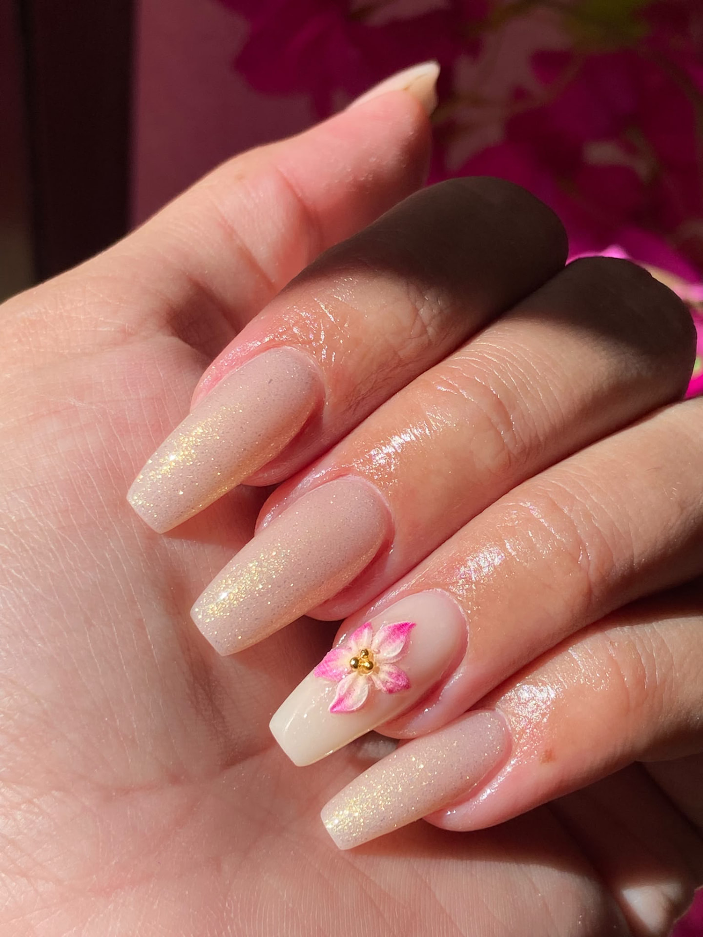 Manicura bailarina nude lechoso con brillo dorado y flor en relieve