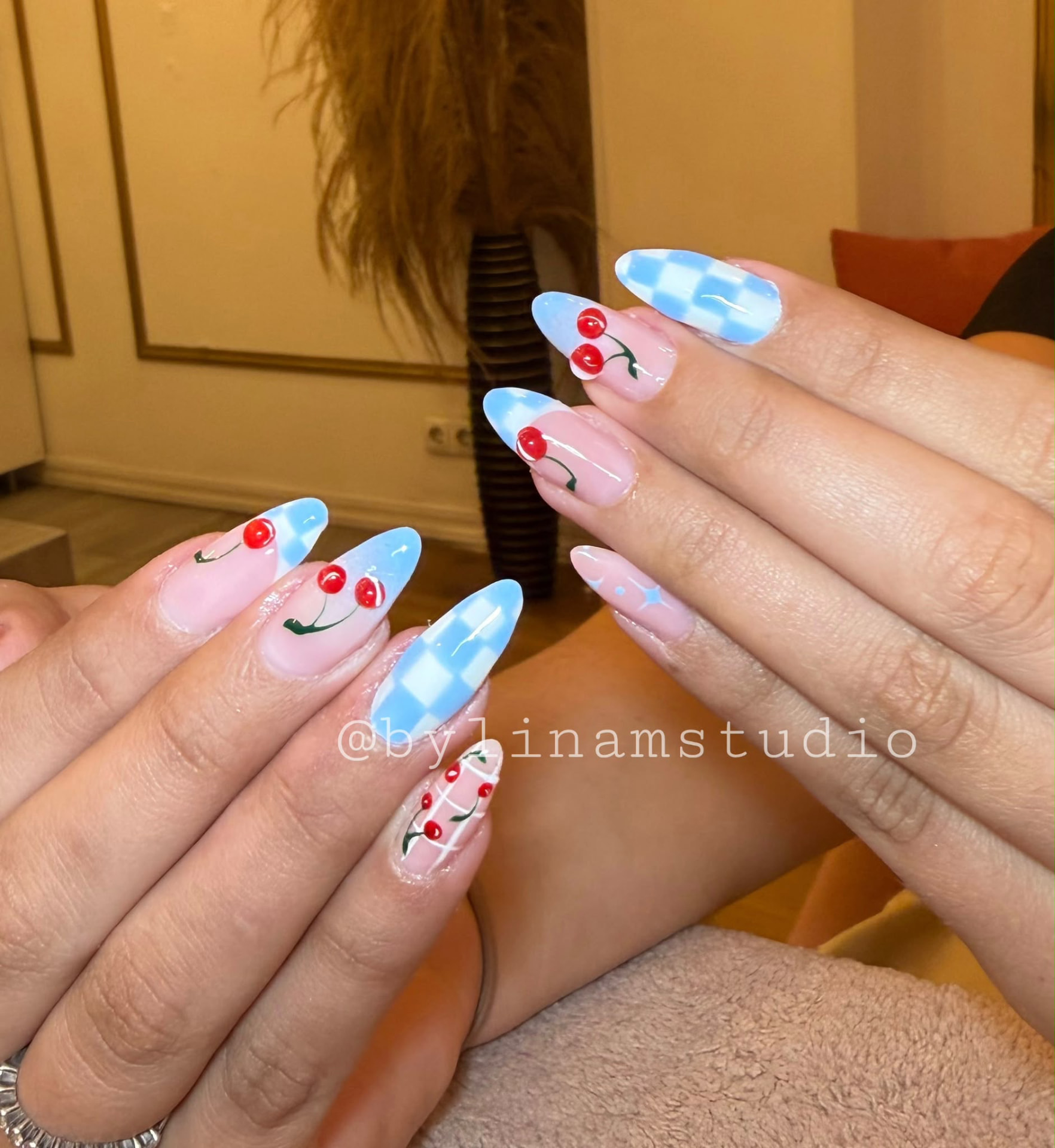 Manicura almendrada nude con damero difuminado y cerezas rojas en relieve